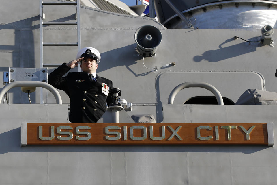 FILE - A member of the USS Sioux City salutes from the Freedom-class of littoral combat ship, during the ship's commissioning ceremony, Nov. 17, 2018, at the U.S. Naval Academy in Annapolis, Md. The Navy that once wanted smaller, speedy warships to chase down pirates has made a speedy pivot to Russia and China and many of those ships, like the USS Sioux City, could be retired. The Navy wants to decommission nine ships in the Freedom-class, warships that cost about $4.5 billion to build. (AP Photo/Patrick Semansky, File)