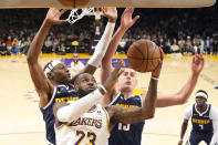 Los Angeles Lakers forward LeBron James (23) shoots as Denver Nuggets forward Peyton Watson (8) and center Nikola Jokic defend during the first half in Game 4 of an NBA basketball first-round playoff series Saturday, April 27, 2024, in Los Angeles. (AP Photo/Mark J. Terrill)