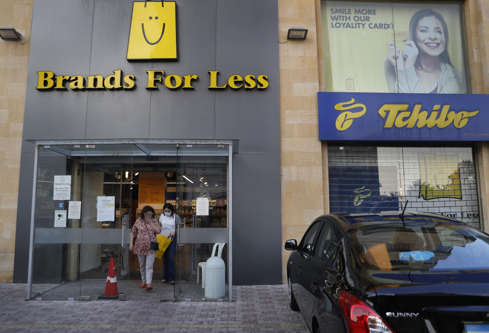 Customers walk out an international fashion and homeware retailer that will temporarily shut down from Friday in the face of an increasingly volatile currency market and their inability to set prices while the Lebanese pound plunges against the dollar, in Beirut, Lebanon, Thursday July 2, 2020. Later in the day, owners of the businesses rallied in central Beirut to denounce the government's inability to handle a deepening economic and financial crisis, and urging others to join them after the Lebanese pound recorded a new low Thursday, selling at nearly 10,000 for a dollar and maintaining the downward slide that saw the national currency lose about 85% of its value over the past months. (AP Photo/Hussein Malla)