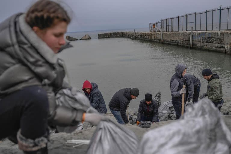 Citizens fill bags with sand for frontlines, along the beach of the Black Sea city of Odessa, in the southern Ukraine on March 7, 2022. - Odessa, which Ukraine fears could be the next target of Russia's offensive in the south, is the country's main port and is vital for its economy. But the city of one million people close to the Romanian and Moldovan borders also holds a special place in the Russian imagination. (Photo by BULENT KILIC / AFP