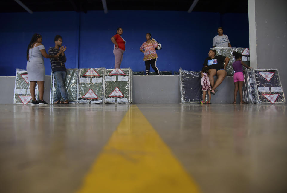 Residents arrive at the William Rivera Vocational School converted into a temporary shelter, before the arrival of Tropical Storm Dorian, in Canovanas, Puerto Rico, Wednesday, Aug. 28, 2019. Dorian became a Category 1 hurricane on Wednesday as it struck the U.S. Virgin Islands, with forecasters saying it could grow to Category 3 status as it nears the U.S. mainland as early as the weekend. (AP Photo/Carlos Giusti)