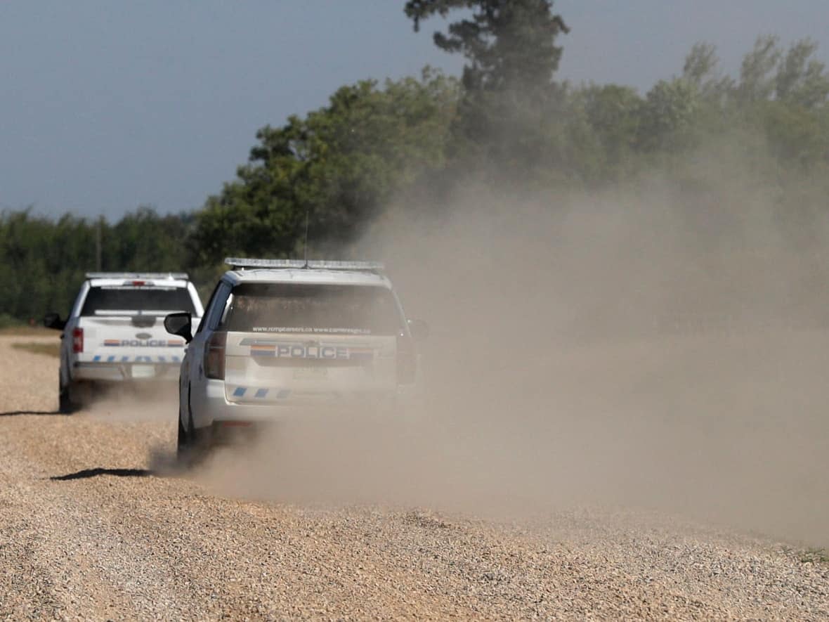 RCMP vehicles patrol James Smith Cree Nation during the search for suspect Myles Sanderson. (Lars Hagberg/AFP via Getty Images - image credit)