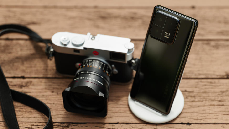 A picture of the Leica M11 camera and a black Xiaomi 13 Pro on a wooden table