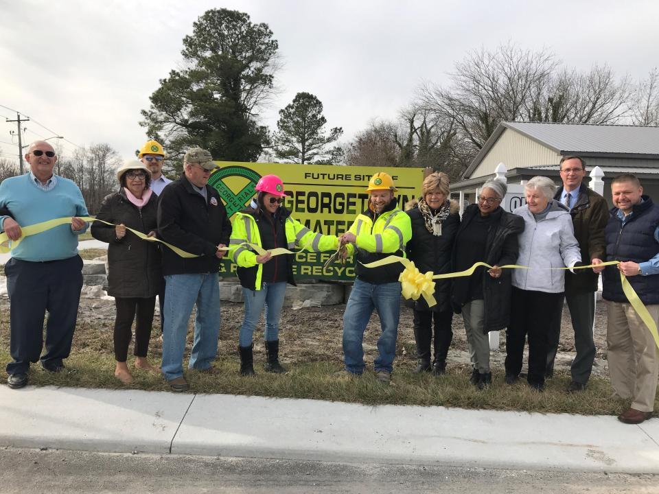 Rich and Jennifer Bell, in yellow, cut the ribbon at Georgetown Materials, on Airport Road in Georgetown, Jan. 13, 2022.