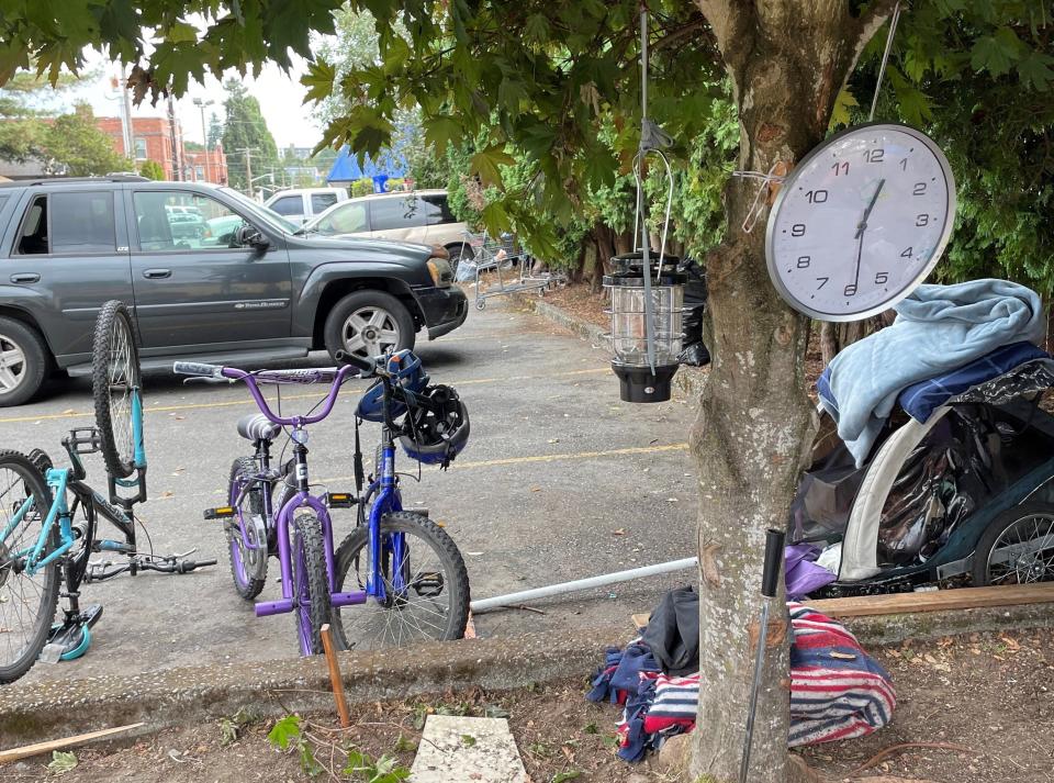 Children's bicycles sit in a parking lot of Broadway Avenue in Bremerton, near a homeless encampment that has developed in recent weeks and drawn public attention as the city continues to wrestle with the issue. The bikes were donated, along with the clock hung in a tree, to a family with children living there.
