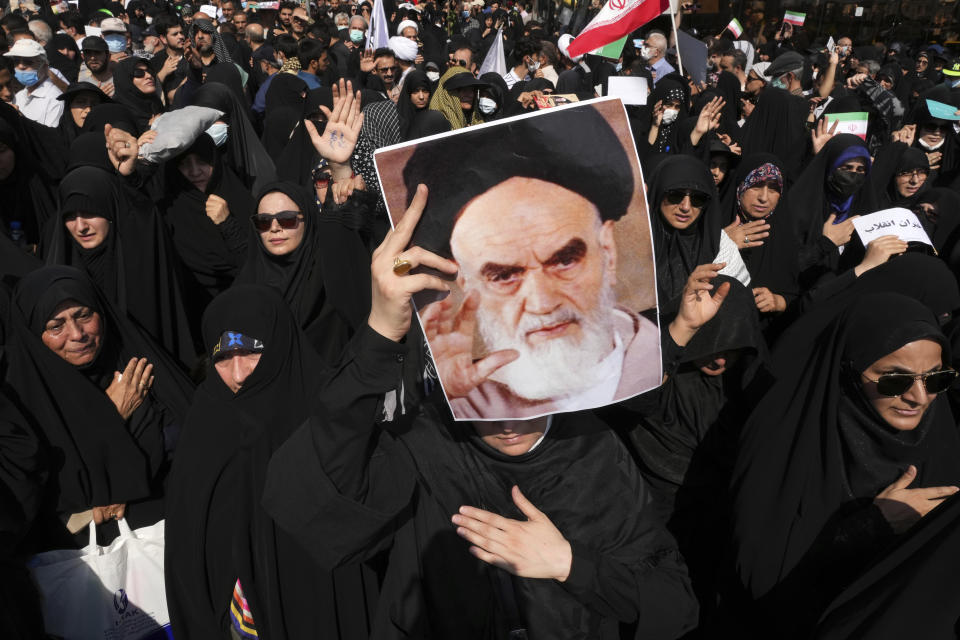 File - A pro-government demonstrator holds a poster of the late Iranian revolutionary founder Ayatollah Khomeini while attending a rally after the Friday prayers to condemn recent anti-government protests over the death of a young woman in police custody, in Tehran, Iran, Friday, Sept. 23, 2022. The crisis unfolding in Iran began as a public outpouring over the the death of Mahsa Amini, a young woman from a northwestern Kurdish town who was arrested by the country's morality police in Tehran last week for allegedly violating its strictly-enforced dress code. (AP Photo/Vahid Salemi, File)