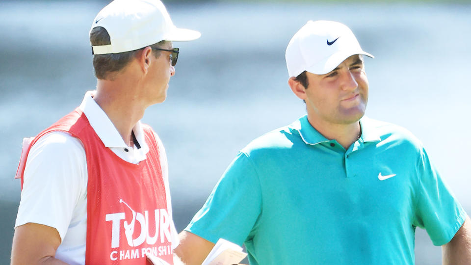 Scottie Scheffler consults with his caddy at the FedEx Cup.