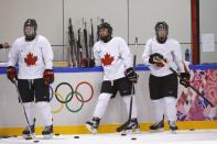 Canada forwards Haley Irwin (L-R), Brianne Jenner and Melodie Daoust wait to shoot during a women's ice hockey team practice at the 2014 Sochi Winter Olympics February 19, 2014. REUTERS/Lucy Nicholson (RUSSIA - Tags: SPORT ICE HOCKEY OLYMPICS)