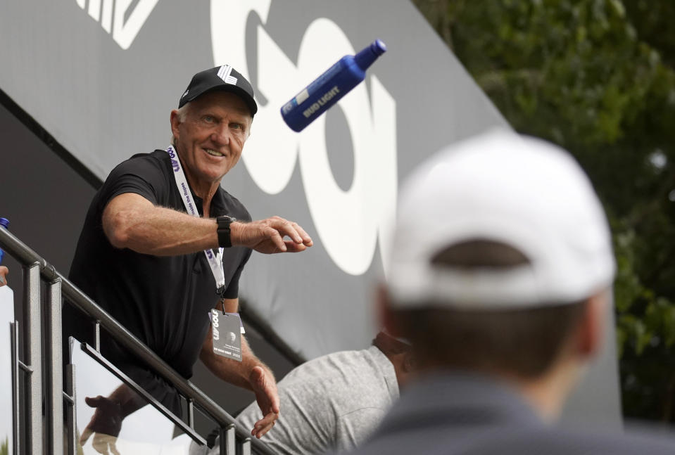 LIV Golf CEO Greg Norman tosses beer to fans on the 18th green during the final round of the LIV Golf Invitational-Boston tournament, Sunday, Sept. 4, 2022, in Bolton, Mass. (AP Photo/Mary Schwalm)