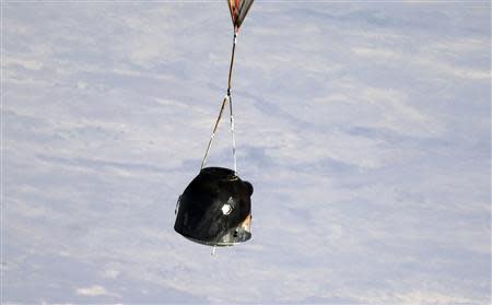 A Russian Soyuz TMA-08M spacecraft carrying Expedition 36 Commander Russian cosmonaut Pavel Vinogradov and Flight Engineers, US NASA astronaut Chris Cassidy and Russian cosmonaut Alexander Misurkin descends beneath a parachute just before landing some 146 km southeast of the town of Zhezkazgan in Kazakhstan, September 11, 2013. REUTERS/Maxim Shipenkov/Pool