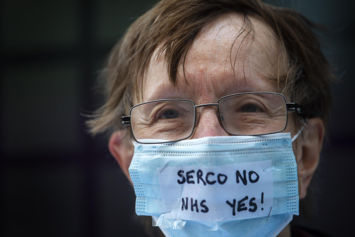 A campaigner outside the Department of Health and Social Care office in London protesting over Serco's handling of the test, track and trace system.