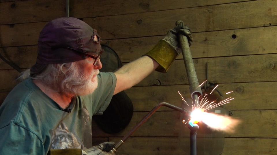 Blacksmith Michael Harrigan welds a rods of metal so it can be twisted into a new shape.