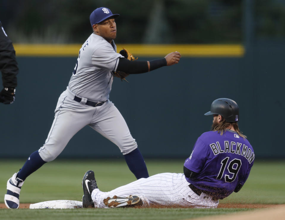 San Diego Padres second baseman Yangervis Solarte, left, forces out Colorado Rockies' Charlie Blackmon at second base on the front end of a double play after a hit by DJ LeMahieu in the first inning of a baseball game Monday, April 10, 2017, in Denver. (AP Photo/David Zalubowski)