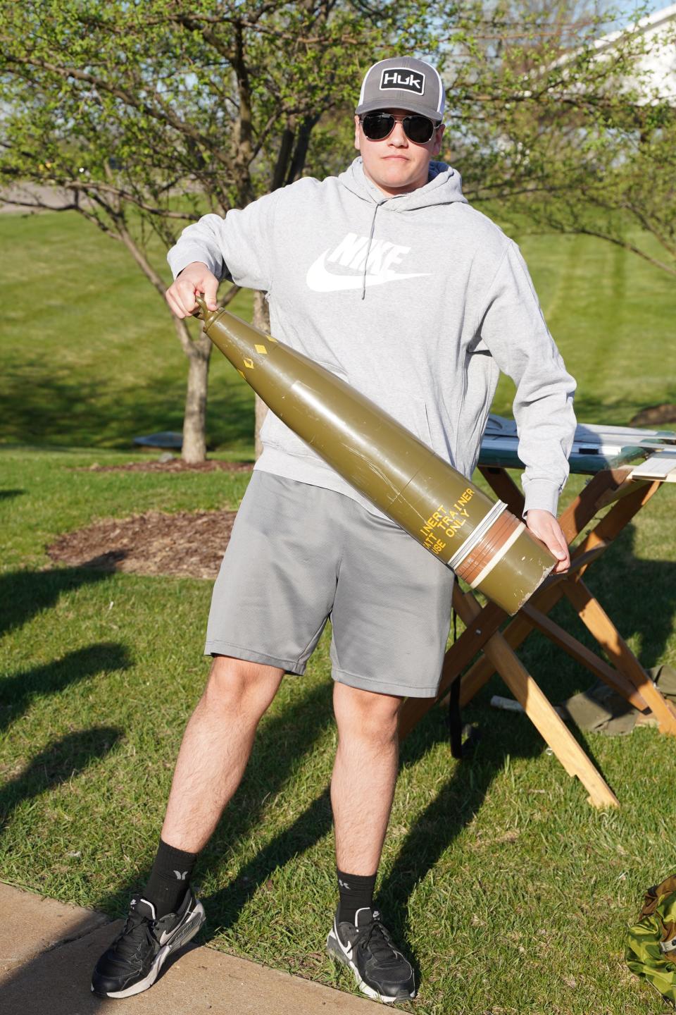 Kaige White of Onsted lifts a 100-pound, dummy 155 mm Howitzer shell during Meet the Army Community Day Friday at Adrian College.