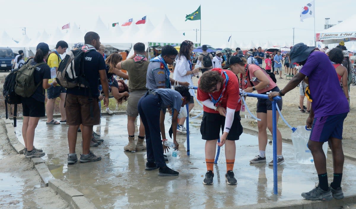 Attendees of the World Scout Jamboree cool off with water at a scout camping site in Buan, South Korea (Kim-yeol/Newsis via AP)