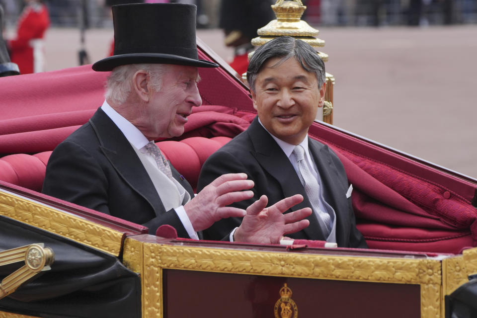 Britain's King Charles III, left, and Emperor Naruhito of Japan arrive at Buckingham Palace during the ceremonial welcome for the State Visit to Britain of the Japanese Emperor and Empress, in London, Tuesday, June 25, 2024. (Jonathan Brady, Pool Photo via AP)