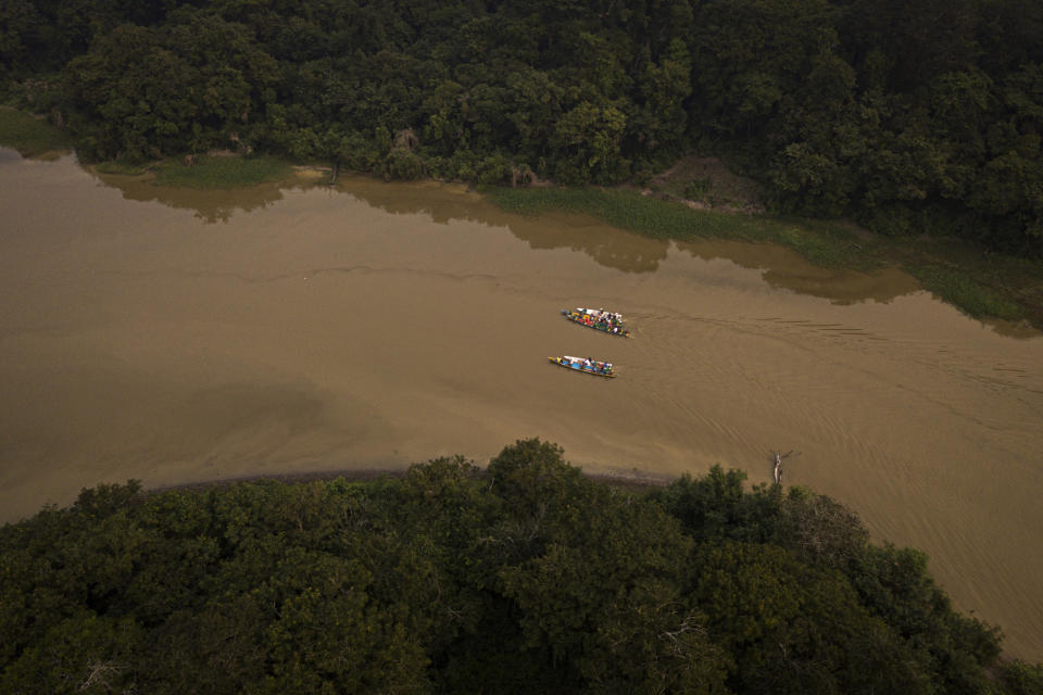 Boat with members of Pirarucu Collective cross a channel from a lake to another at San Raimundo settlement, in Carauari, Brazil, Monday, Sept. 5, 2022. Indigenous communities working together with non-Indigenous riverine settlers manage the pirarucu in preserved areas of the Amazon. Most of it is exported, and the U.S. is the primary market. (AP Photo/Jorge Saenz)