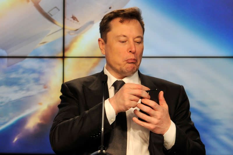 FILE PHOTO: SpaceX founder and chief engineer Elon Musk looks at his mobile phone during a post-launch news conference to discuss the SpaceX Crew Dragon astronaut capsule in-flight abort test at the Kennedy Space Center