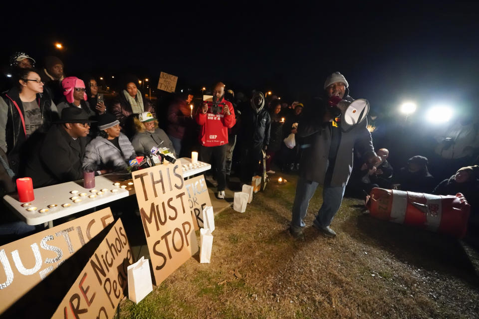 Rev. Andre E Johnson, of the Gifts of Life Ministries, preaches at a candlelight vigil for Tyre Nichols, who died after being beaten by Memphis police officers, in Memphis, Tenn., Thursday, Jan. 26, 2023. Behind him, seated center, are Tyre's mother RowVaughn Wells and his stepfather Rodney Wells. (AP Photo/Gerald Herbert)