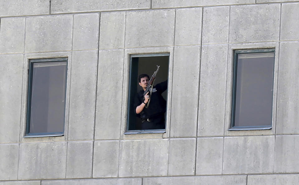 FILE - An armed man stands in a window of the parliament building during an attack by militants in Tehran, Iran on June 7, 2017. An Iranian court issued a $312.9 million judgement against the United States over a 2017 Islamic State-claimed attack on Tehran, authorities said Wednesday, April 26, 2023, the latest judicial action between the nations amid their decadeslong enmity. (Omid Vahabzadeh/Fars News Agency via AP, File)