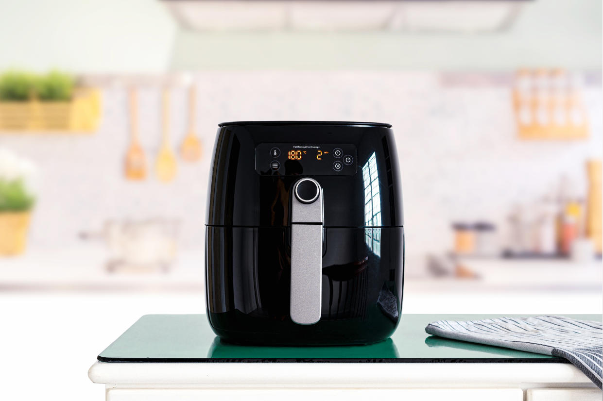 Air fryer machine cooking potato fried in kitchen.  Lifestyle of new normal cooking.