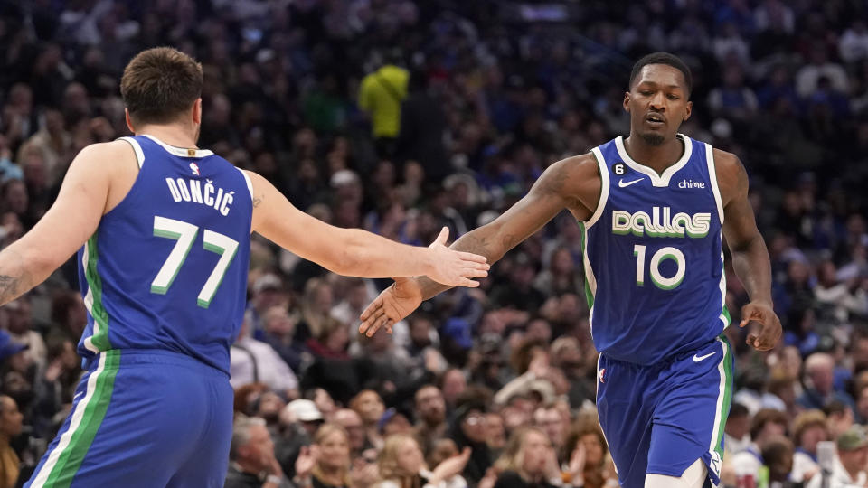 Dallas Mavericks forward Dorian Finney-Smith (10) gets congratulations from teammate guard Luka Doncic (77) after Finney-Smith scored during the first half of an NBA basketball game against the Washington Wizards in Dallas, Tuesday, Jan. 24, 2023. (AP Photo/LM Otero)