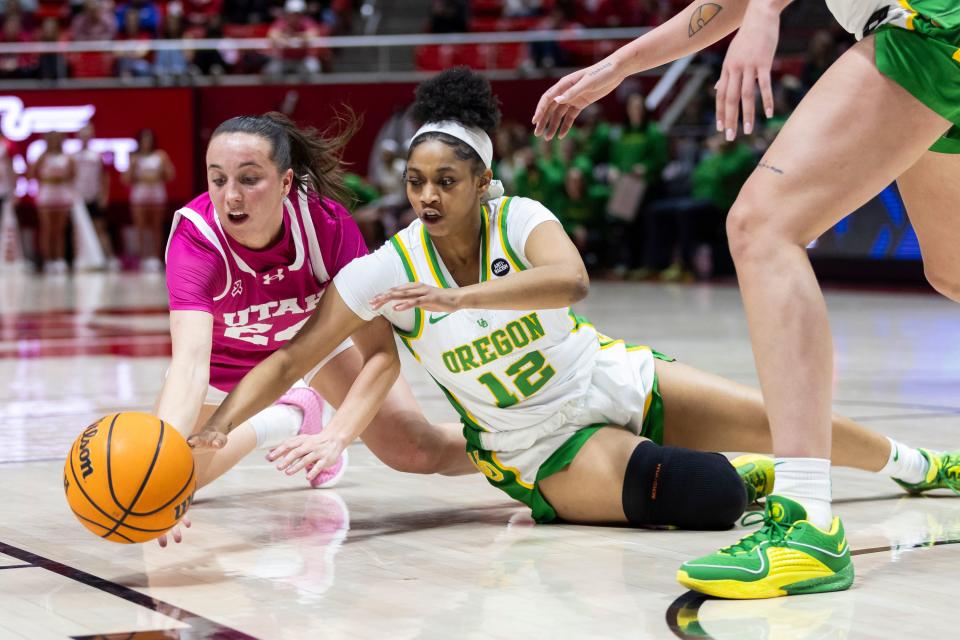 Utah Utes guard Kennady McQueen (24) and Oregon Ducks guard Kennedi Williams (12) fight to reach the ball during a game in Salt Lake City on Saturday, Feb. 11, 2023.