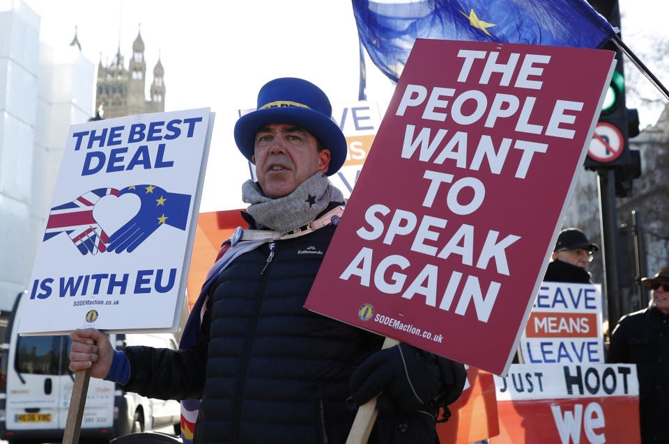 Anti Brexit protester Steve Bray who is almost permanently demonstrating outside the Houses of Parliament watches the traffic as he holds up placards in London, Monday, Jan. 28, 2019. British Prime Minister Theresa May faces another bruising week in Parliament as lawmakers plan to challenge her minority Conservative government for control of Brexit policy.  (AP Photo/Alastair Grant)