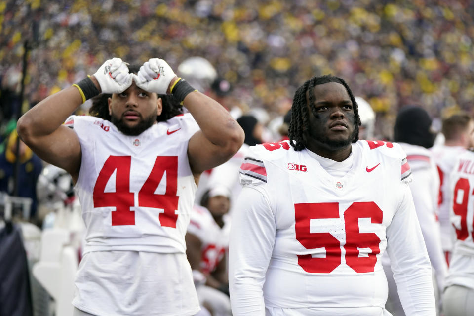 Ohio State defensive end JT Tuimoloau (44) and defensive lineman Kayden McDonald (56) watch the scoreboard during the closing minute of an NCAA college football game against Michigan, Saturday, Nov. 25, 2023, in Ann Arbor, Mich. (AP Photo/Carlos Osorio)