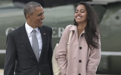 Barack Obama and daughter Malia make their way to board Air Force One - Credit: MANDEL NGAN/AFP