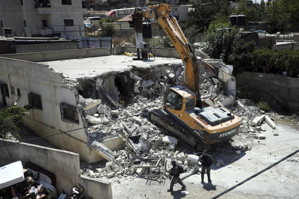 Israeli authorities demolish a Palestinian owned house in east Jerusalem, Wednesday, Aug. 21, 2019. Jerusalem's municipality has carried out the court-ordered demolition of what it said was an illegally built Palestinian home in the city's eastern sector. Jerusalem's Palestinian population has long complained that it faces discriminatory housing policies that favor Jews. They say it is virtually impossible to get a building permit and have no choice but to build without them.(AP Photo/Mahmoud Illean)