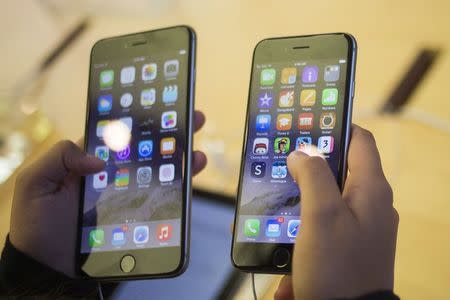 A customer holds an iPhone 6 (R) and iPhone 6 Plus after the phones went on sale at the Fifth Avenue Apple store in Manhattan, New York September 19, 2014. REUTERS/Adrees Latif