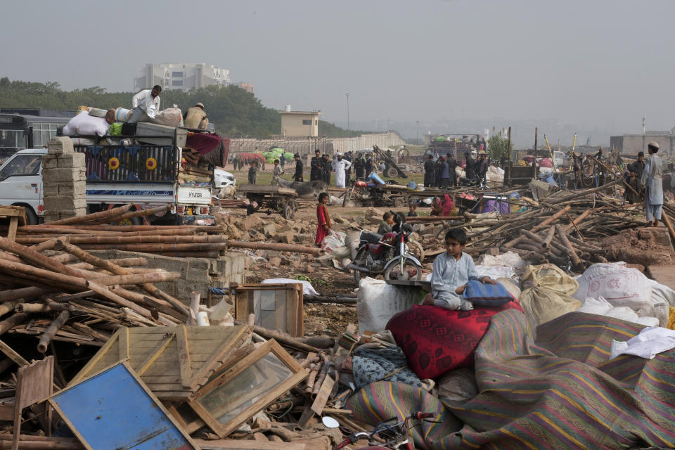 Afghans load their belongings onto a vehicle after retrieving them from their damaged mud homes demolished by authorities during a crackdown against in an illegal settlement and immigrants, on the outskirts of Islamabad, Pakistan, Wednesday, Nov. 1, 2023. (AP Photo/Anjum Naveed)