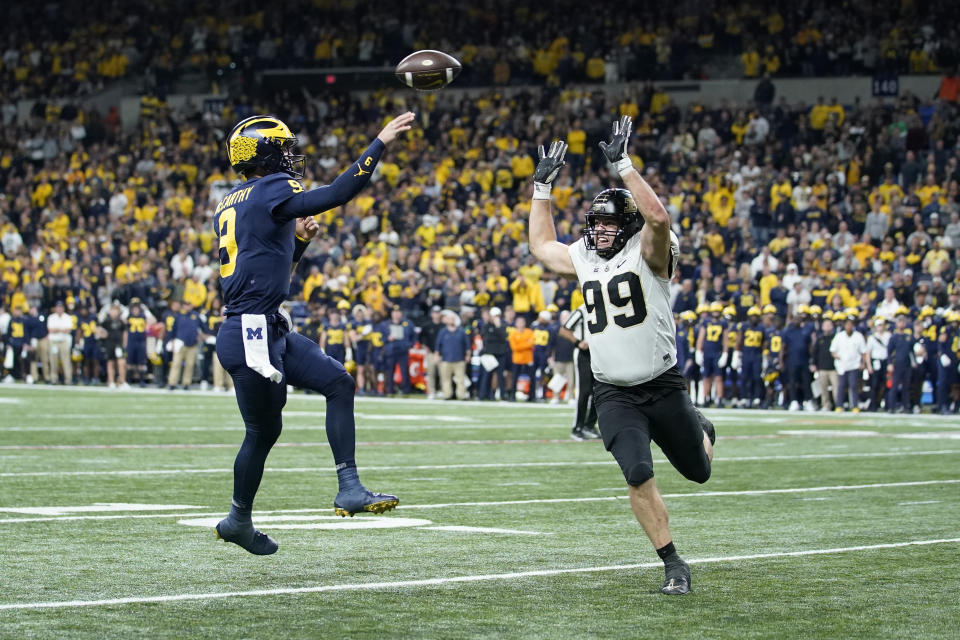 Michigan quarterback J.J. McCarthy (9) throws for a 2-point conversion over Purdue defensive end Jack Sullivan (99) during the second half of the Big Ten championship NCAA college football game, Saturday, Dec. 3, 2022, in Indianapolis. (AP Photo/Michael Conroy)