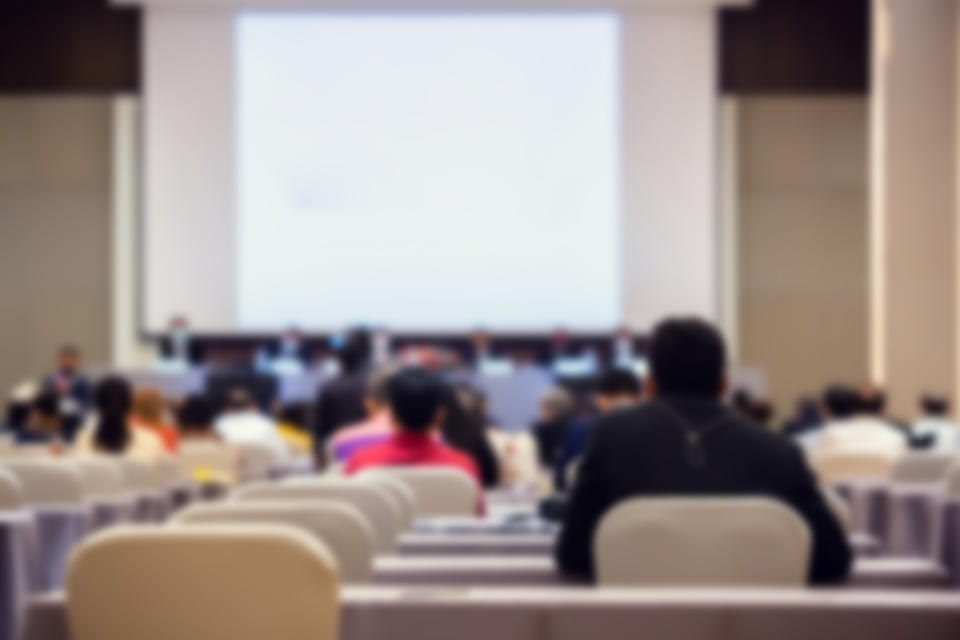 Blurry of auditorium for shareholders' meeting or seminar event with projector, Annual shareholder meeting.