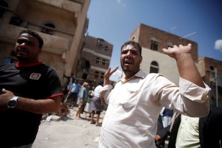 FILE PHOTO: People react at the site of an air strike launched by the Saudi-led coalition in Sanaa