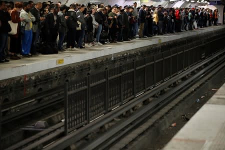 Commuters wait to board a metro at the Gare du Nord subway station during a strike by all unions of the Paris transport network (RATP) against pension reform plans in Paris