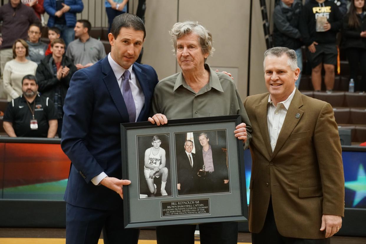 Former Providence Journal sports columnist Bill Reynolds, center, is presented with an award by Brown basketball coach Mike Martin, left, and athletic director Jack Hayes before Reynolds' induction in 2020 into the National College Basketball Writers Hall of Fame.