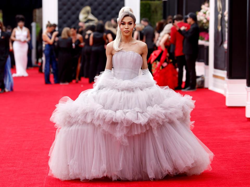 Trinity in a strapless mauve blush tulle gown with a voluminous tiered skirt.