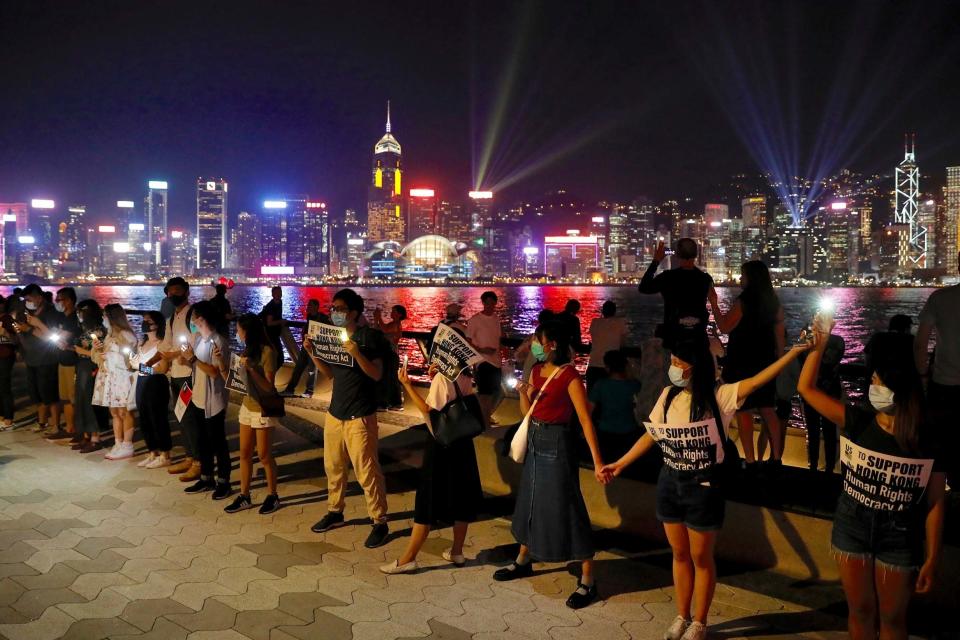 Demonstrators link hands as they gather at the Tsim Sha Tsui waterfront in Hong Kong. (AP)