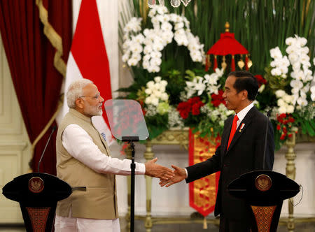 Indian Prime Minister Narendra Modi (L) shakes hands with Indonesia President Joko Widodo after they spoke following their meeting at the presidential palace in Jakarta, Indonesia May 30, 2018. REUTERS/Darren Whiteside