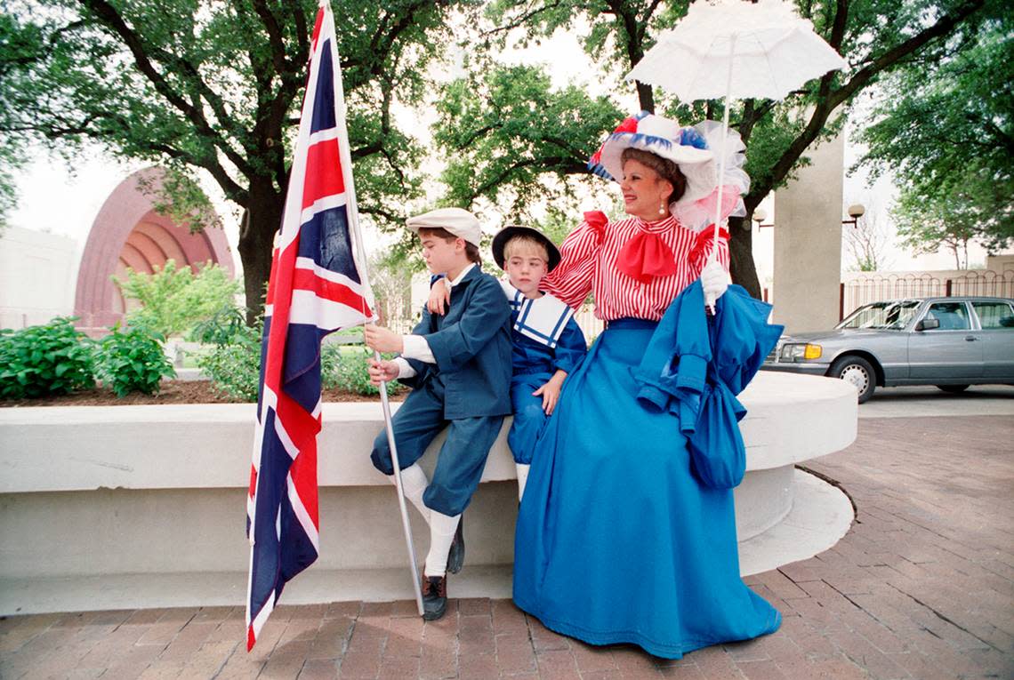 A woman and two boys in costume in honor of Queen Elizabeth II’s visit to Dallas.