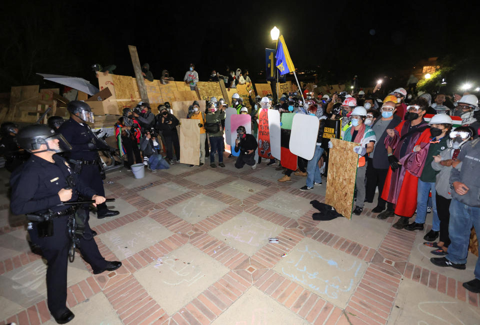 身著戰術裝備的警察1日在美國加州大學洛杉磯分校（UCLA）校園中遭到示威者占據的帳篷群附近列隊，準備清理前一晚遭到親以色列支持者攻擊的挺巴勒斯坦抗議營地。（路透社）