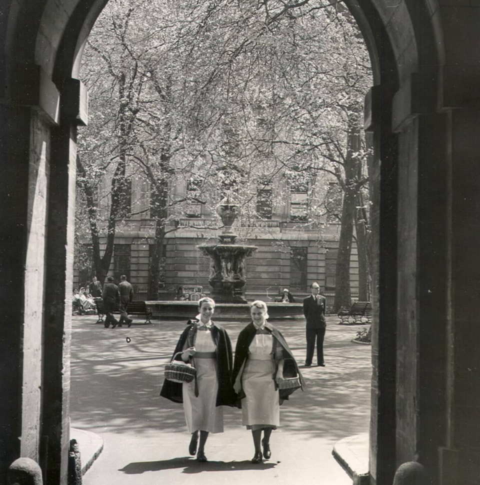 Two nurses walking through the archway of the North Wing, 22 May 1954: Two nurses walking through the archway of the North Wing, 22 May 1954 (Barts Health NHS Trust Archives)