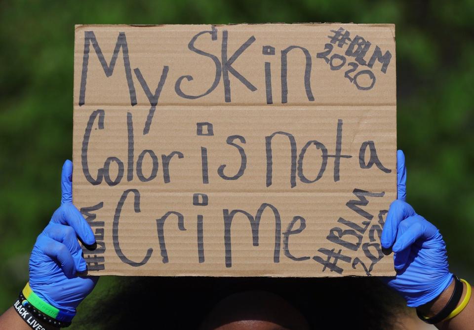 A protester in Kent wears latex gloves to help slow the spread of coronavirus during a June 2020 Black Lives Matter protest.