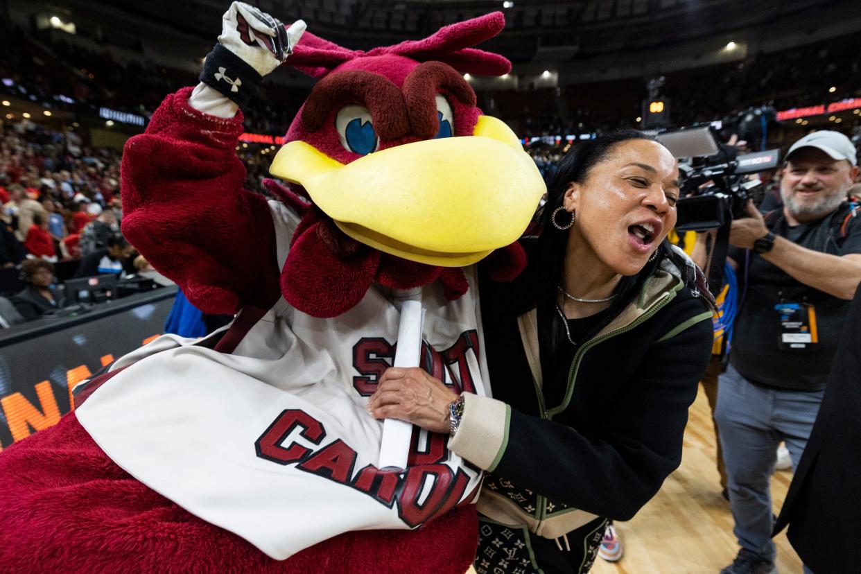 South Carolina coach Dawn Staley celebrates with the Gamecocks mascot, "Cocky," after defeating Maryland in the Elite Eight.