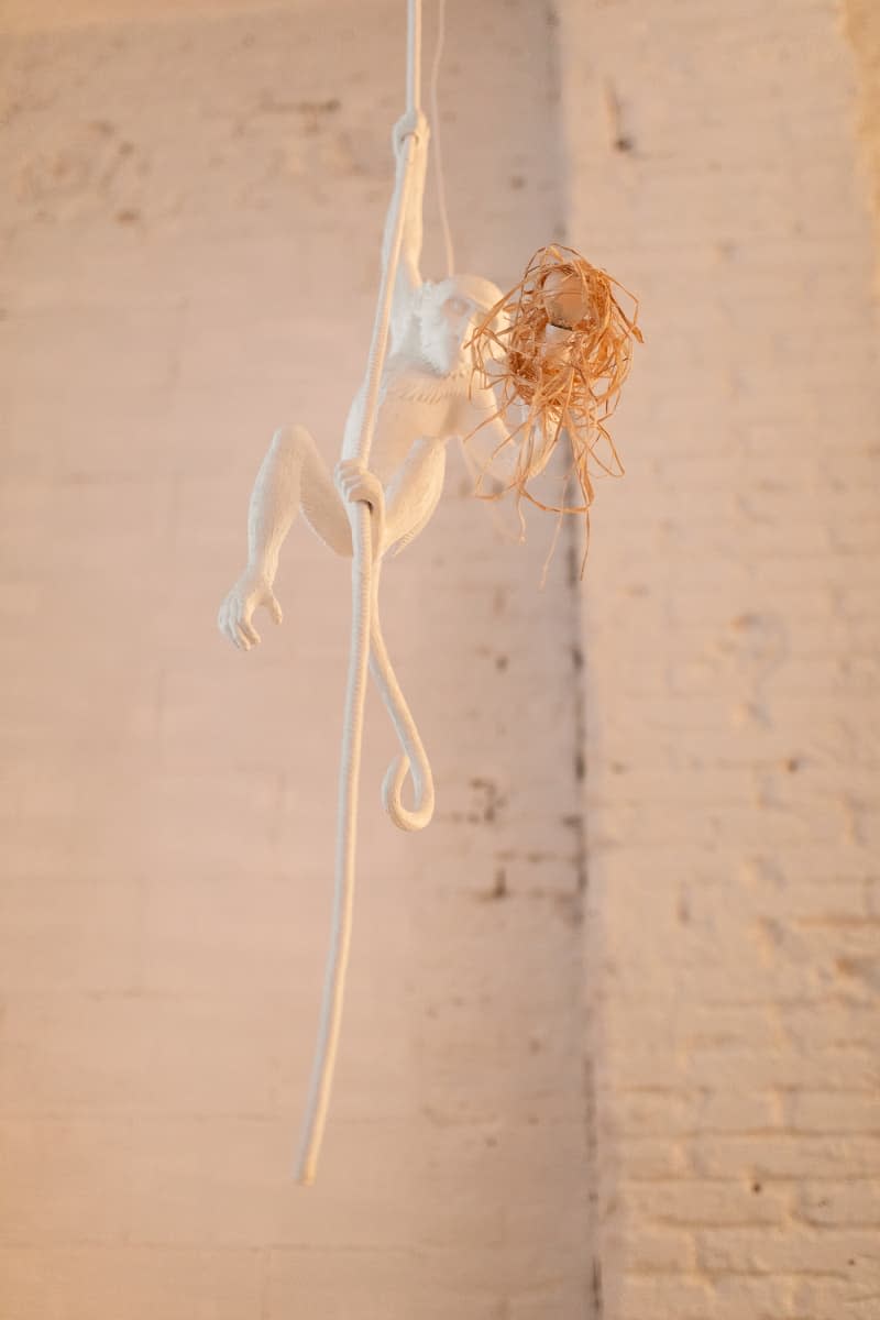 white hanging monkey figure  in loft apartment