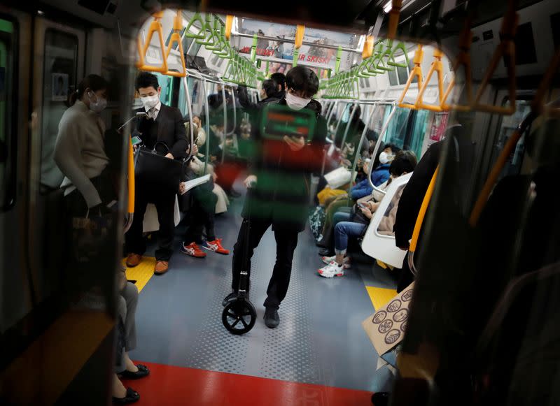 FILE PHOTO: Passengers wearing masks inside a train in Tokyo, Japan