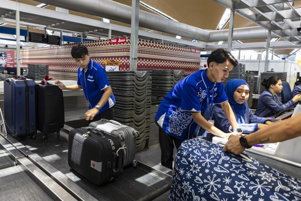 Malaysian Airlines ground staff at a check-in counters at Kuala Lumpur International Airport.  Photographer: Richard Humphries/Bloomberg