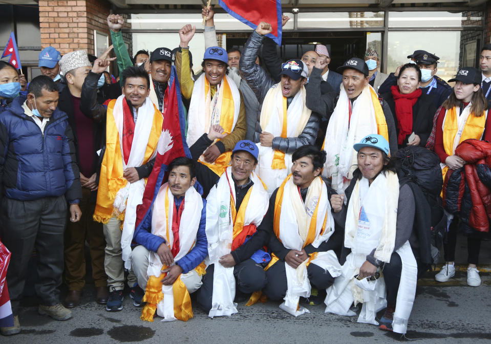 The all-Nepalese mountaineering team that became the first to scale Mount K2 in winter pose for the media as they arrive at Tribhuwan International airport in Kathmandu, Nepal, Tuesday, Jan. 26, 2021. (AP Photo/Niranjan Shrestha)